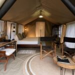 A view of the bed, dek and loung of a Enkishui Safari Camp guest safari tent